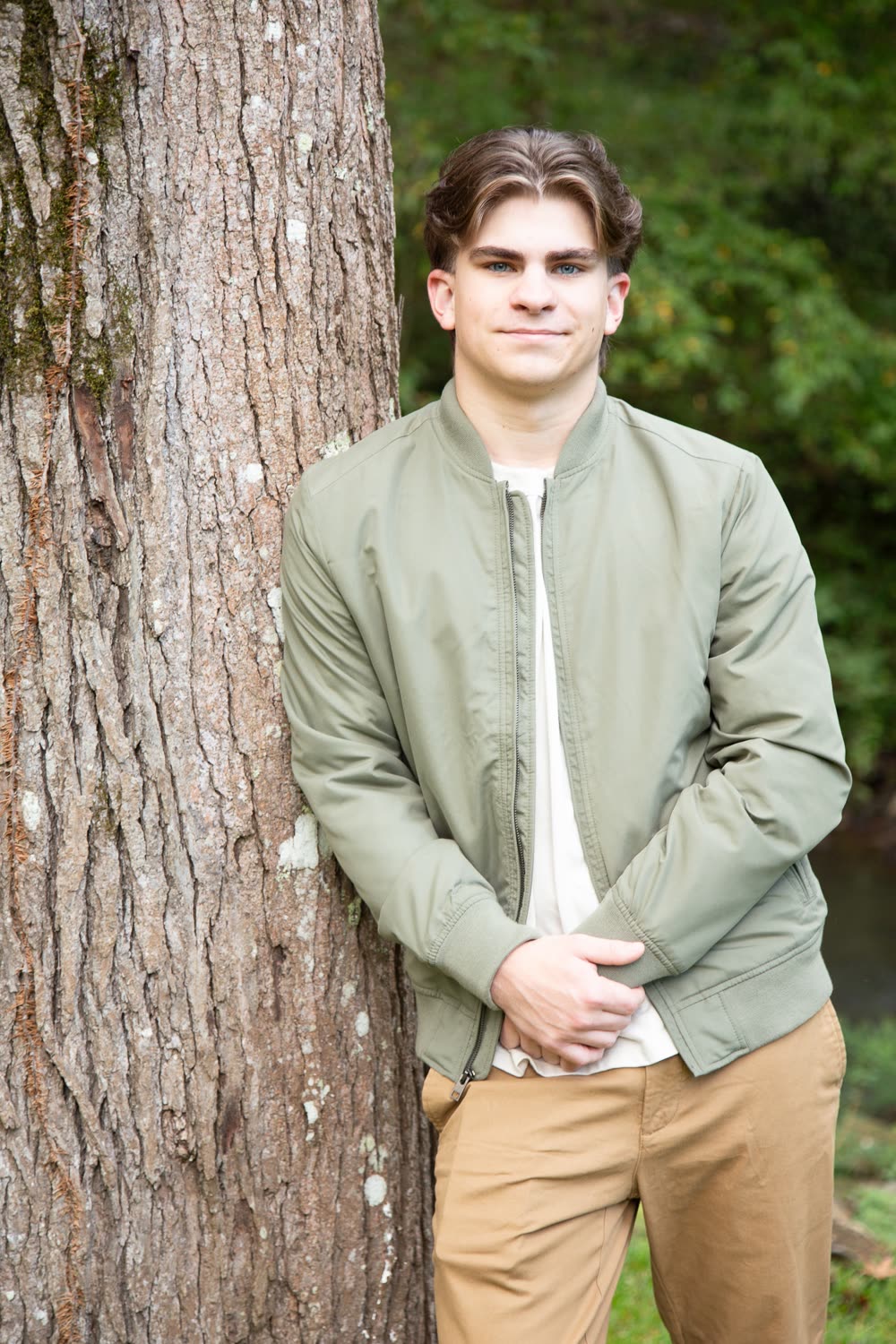 Preston Andersen outdoors, leaning against a tree